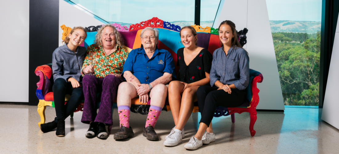 Two older men sitted between 3 young girls 